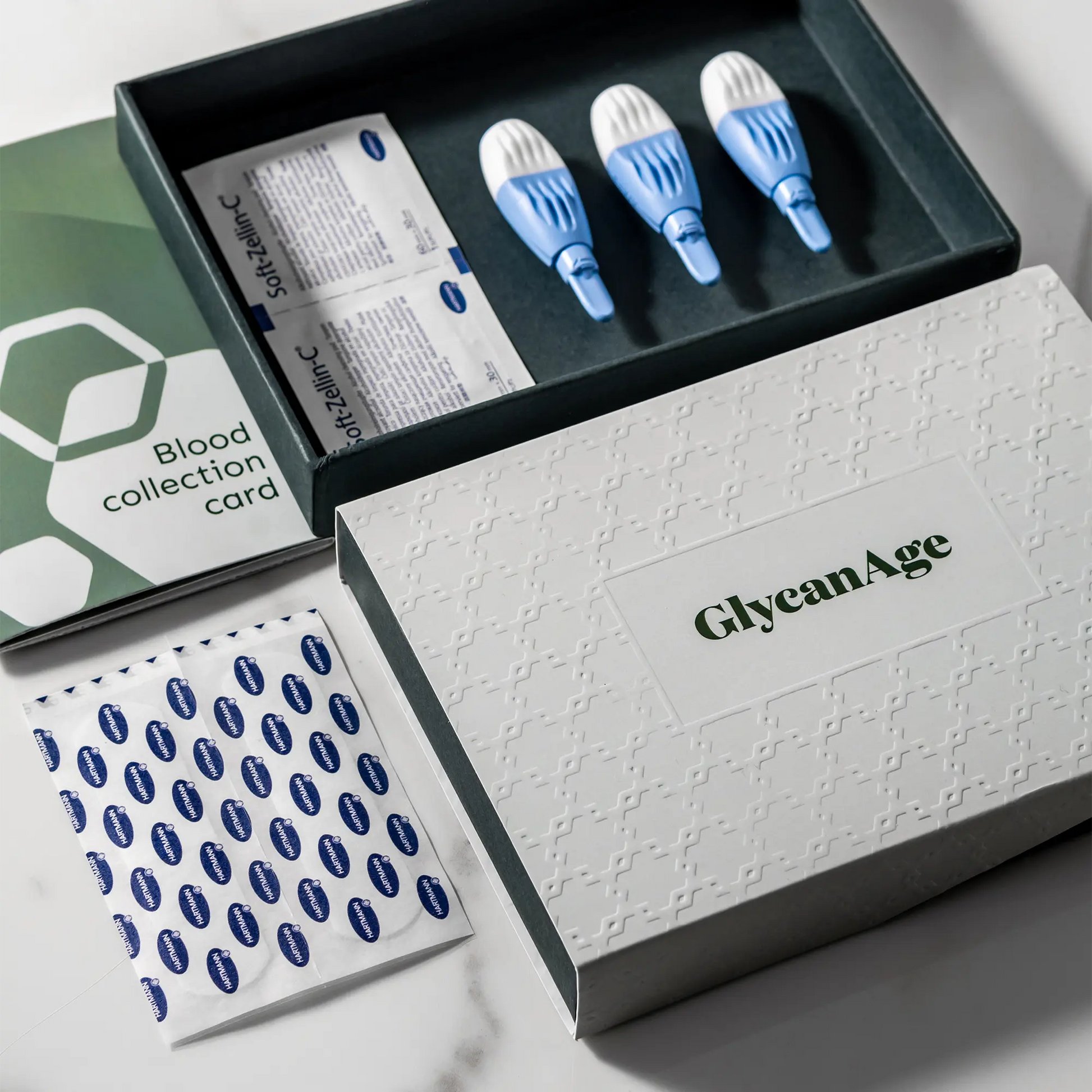 GlycanAge home blood test kit with lancets, blood collection card, and sterile wipes